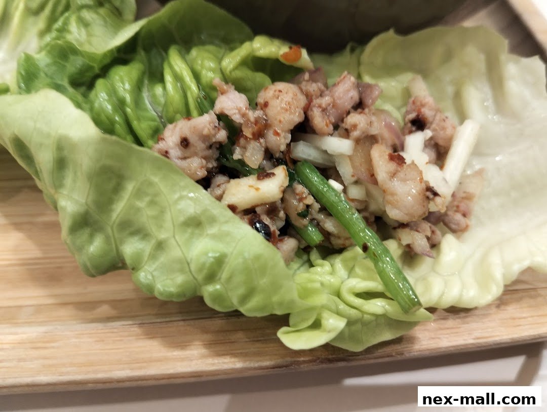 A close-up of a delicious lettuce wrap filled with seasoned minced meat and vegetables.