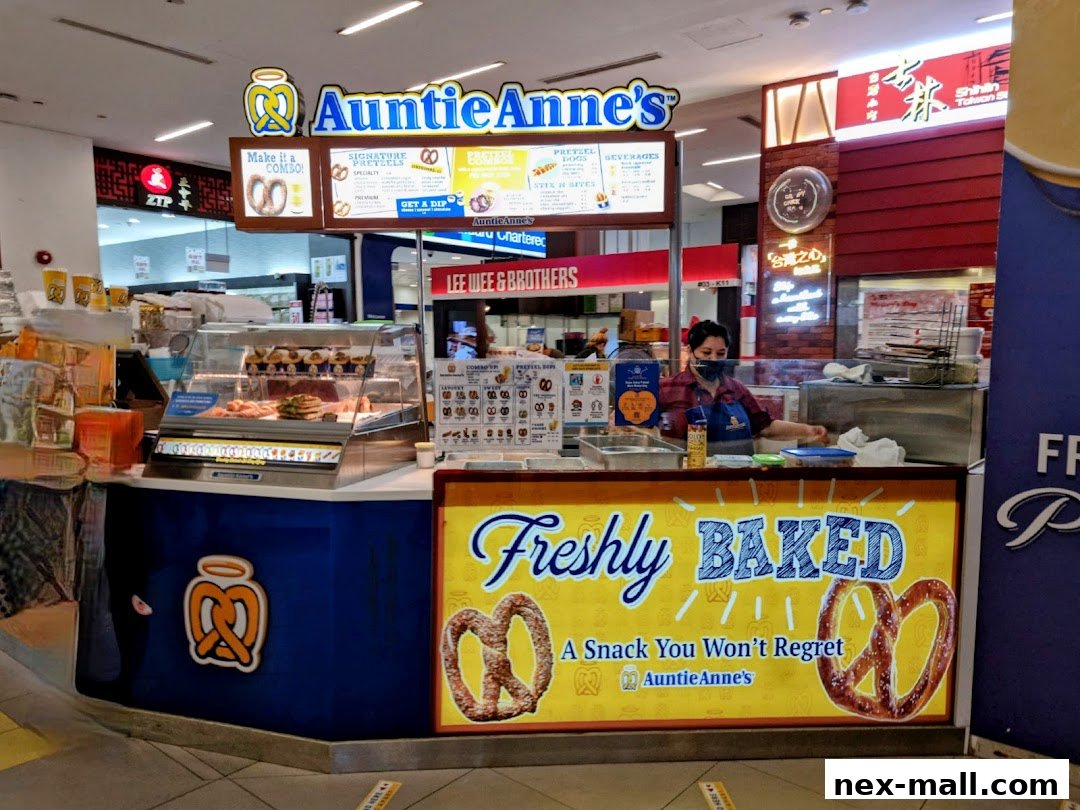 Auntie Anne's pretzel shop counter with a staff member and freshly baked pretzels displayed.