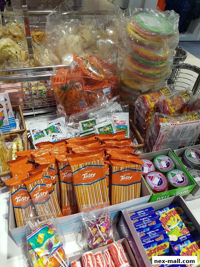 A display of various snacks and candies, including biscuit sticks, lollipops, and small packaged treats.