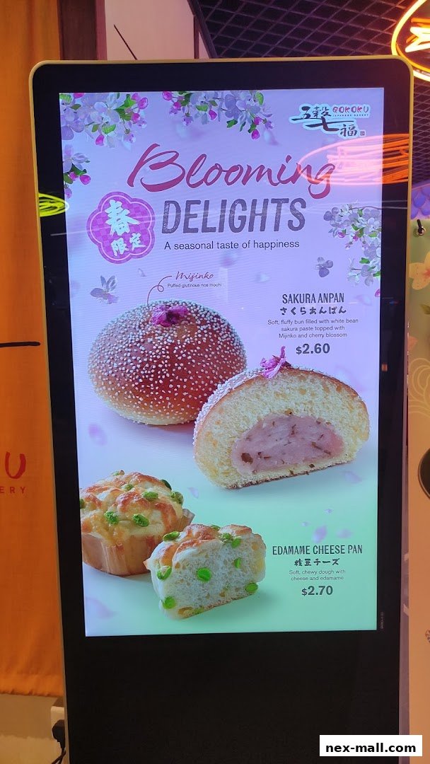 A digital menu board showcasing Japanese bakery items with cherry blossom theme.