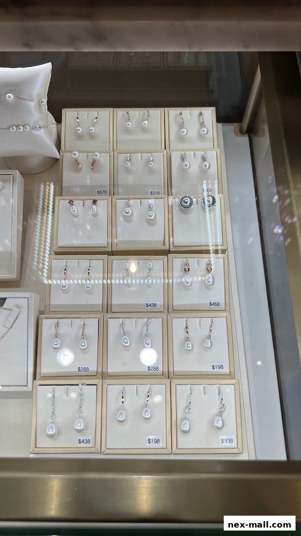 A display case filled with various pearl earrings and a bracelet from LEE HWA.