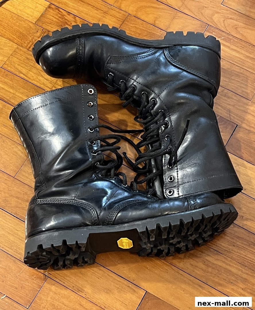 A pair of shiny black leather combat boots with thick soles and laces.