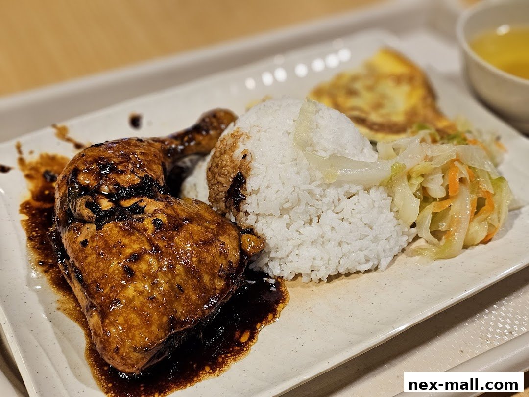 A close-up of a delicious meal featuring glazed chicken, rice, and a side of vegetables.