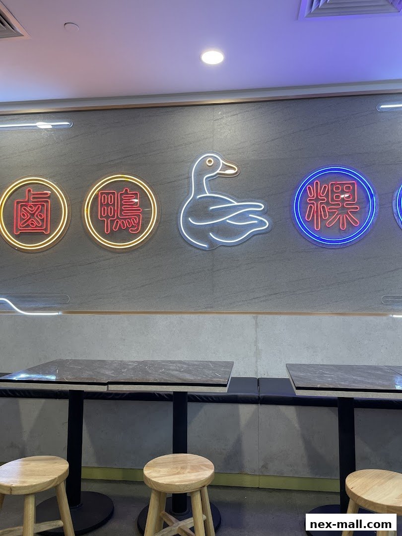 Interior shot of Yew Kee Specialities with neon signs and seating.