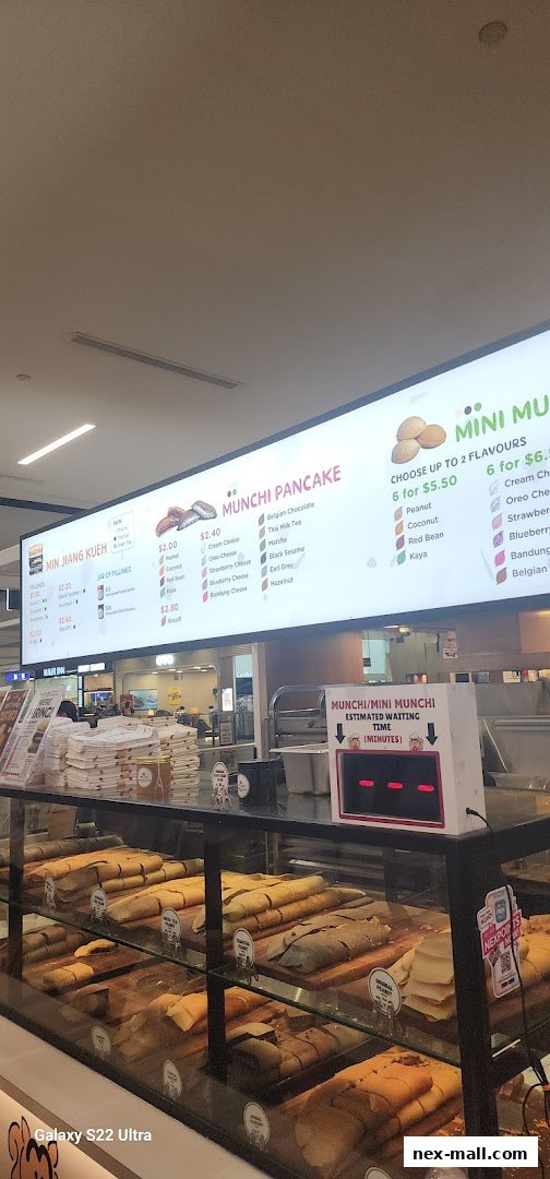 A display case filled with various types of pancakes and a menu board above.