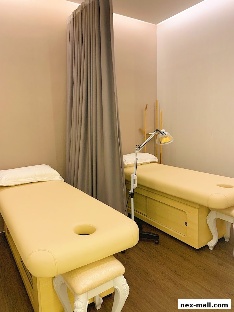Two clean massage beds with face cradles and a lamp in a treatment room.