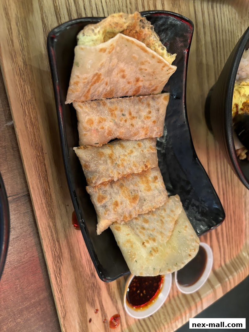 A close-up shot of Taiwanese scallion pancakes with dipping sauce.