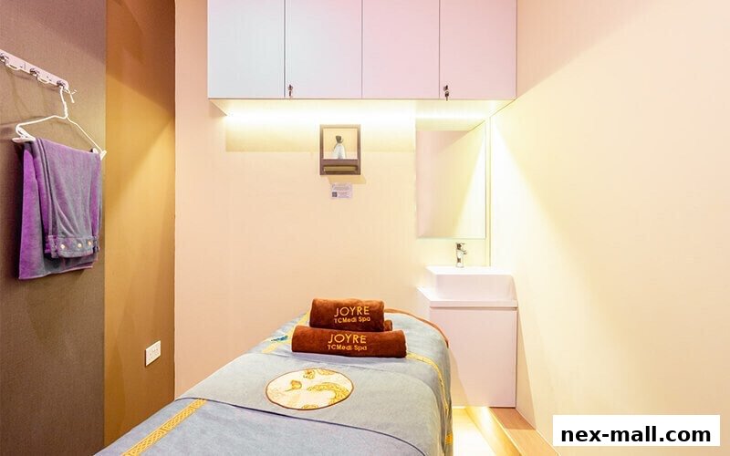 A treatment room at Joyre TCMedi Spa with a massage bed, towels, and a sink.