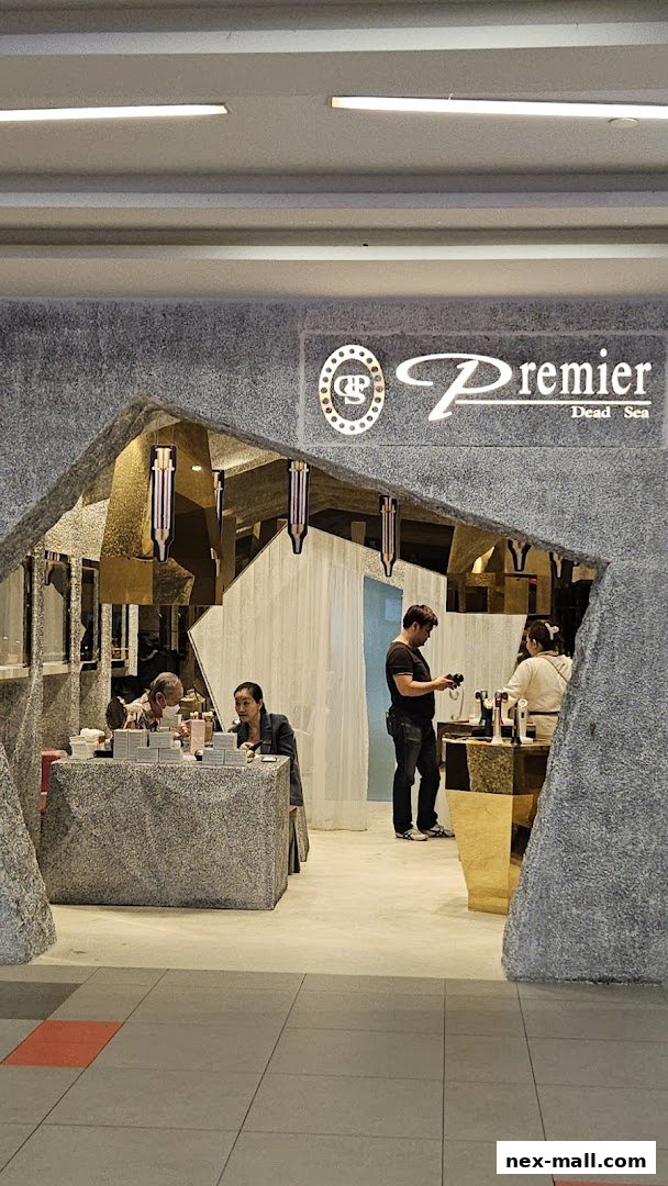 The entrance of Premier Dead Sea NEX shop with staff and customers inside.
