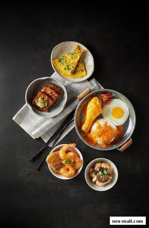 A spread of delicious Hainanese dishes including fried chicken, rice, omelette, and seafood.
