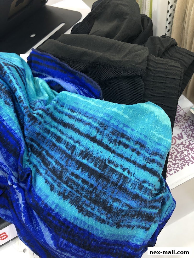 A pile of colorful blue and black patterned clothing items, likely activewear or swimwear.