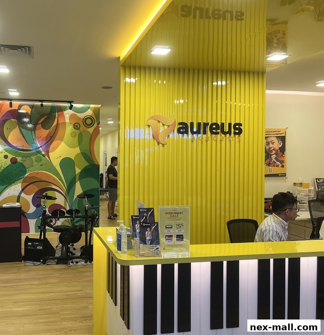 The reception area of Aureus Academy features a bright yellow wall with the academy's logo and a piano-themed counter.
