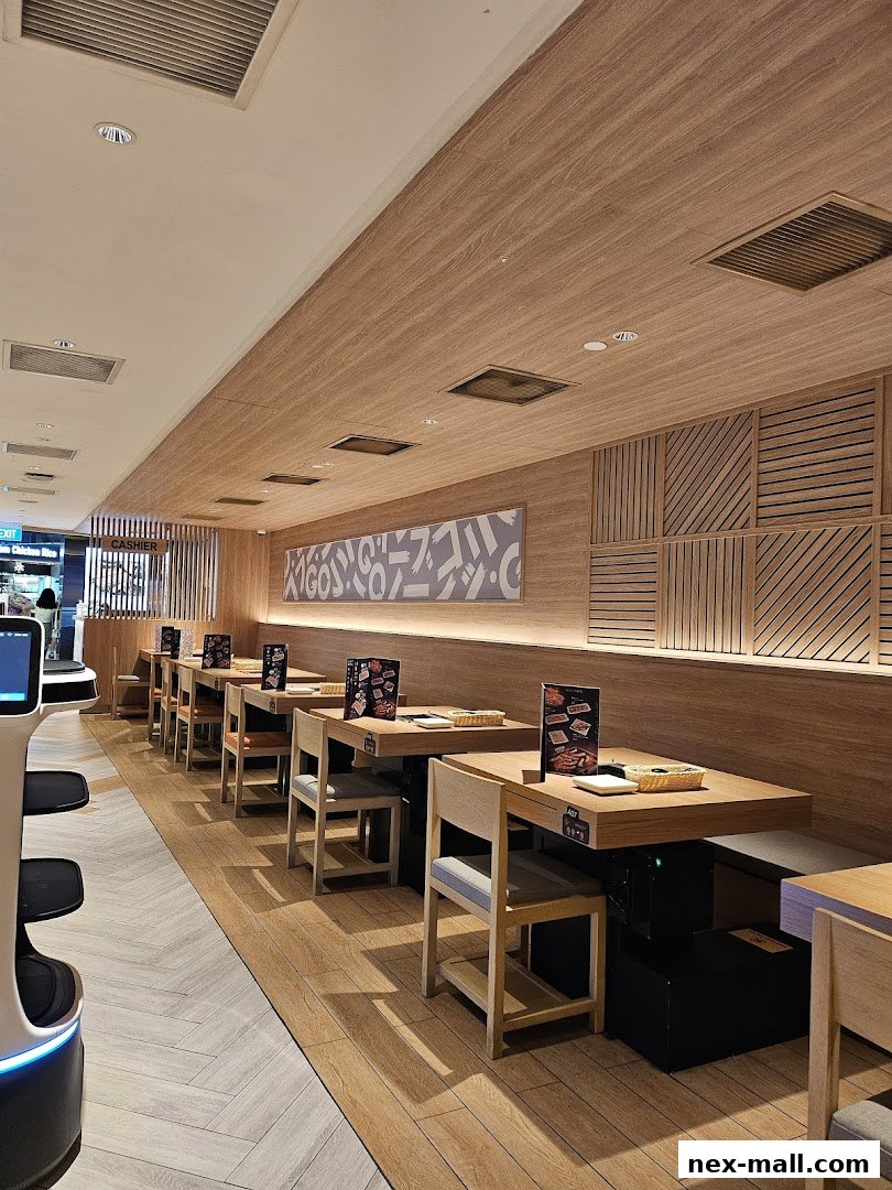 Interior view of a Yakiniku-GO NEX restaurant with clean tables and modern wooden decor.