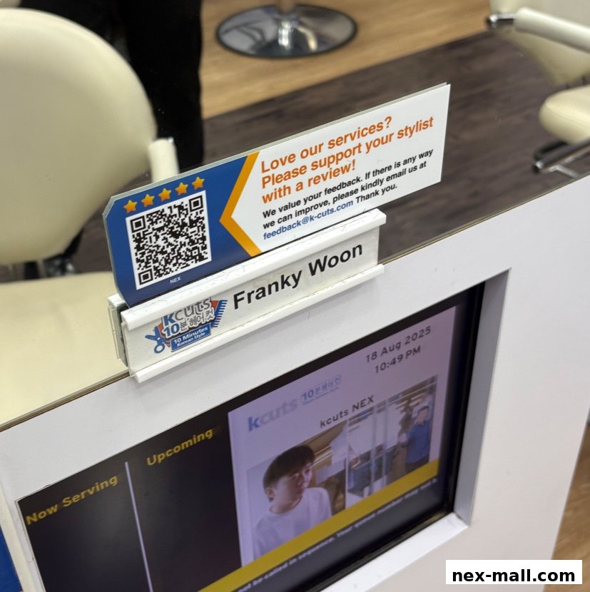 A sign at kcuts Nex asking for customer reviews and displaying stylist information.