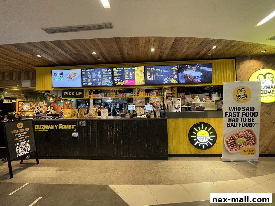 The Guzman y Gomez shop front with a pick-up counter and digital menus displaying food options.