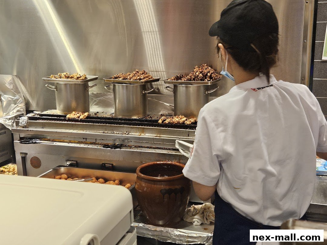 A chef prepares skewers of meat in a busy kitchen at TORI-Q.