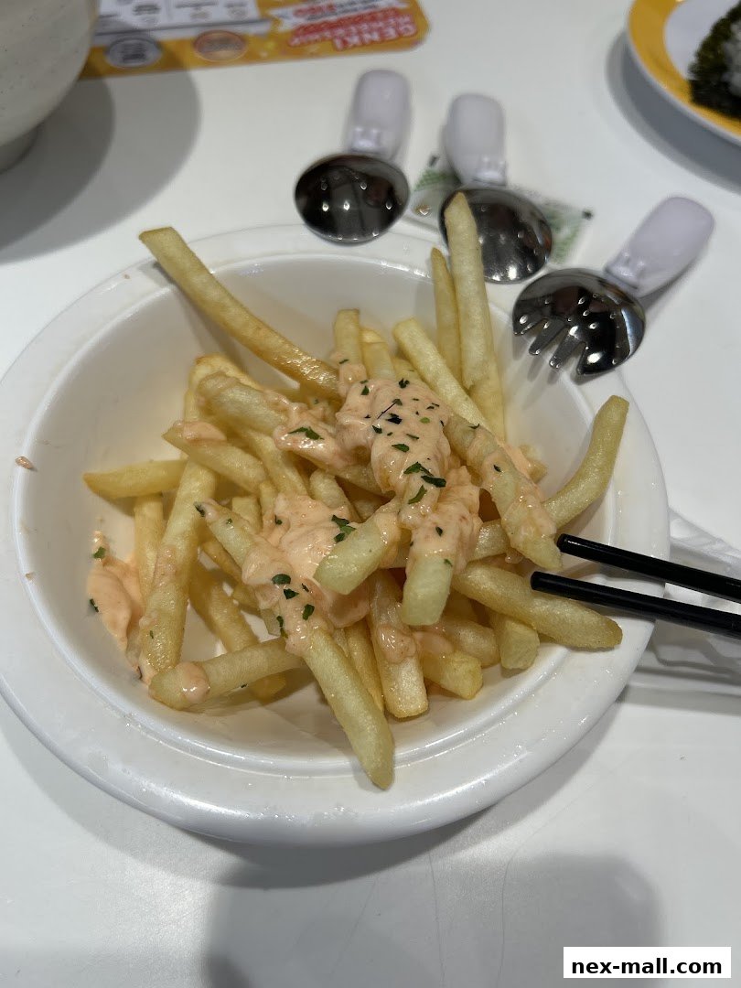 A bowl of french fries topped with sauce and parsley, served with chopsticks.