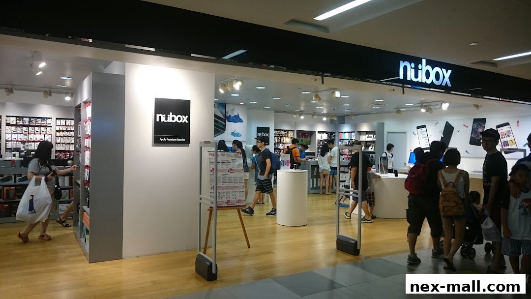 The entrance of a modern electronics store, showcasing Apple products and accessories.