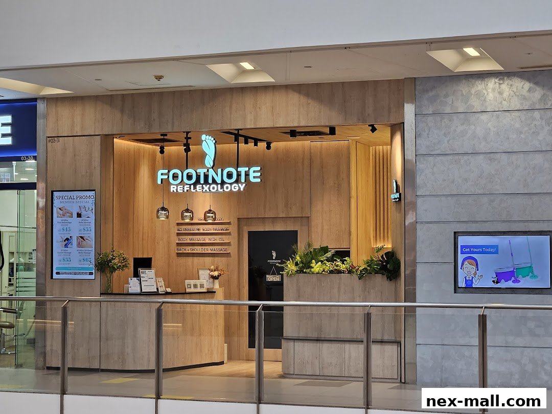 The entrance of FootNote Reflexology, a wellness spa with a modern, wooden facade and illuminated signage.