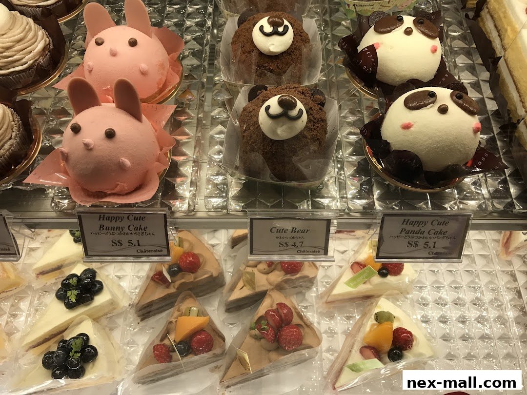 A display case filled with various cute animal-themed cakes and sliced cakes.