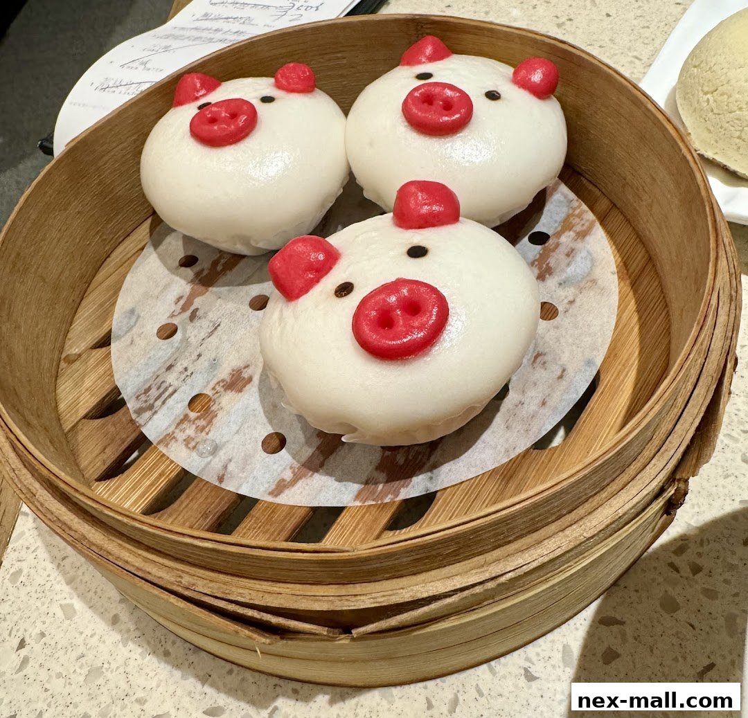 Three adorable pig-shaped steamed buns served in a bamboo steamer.