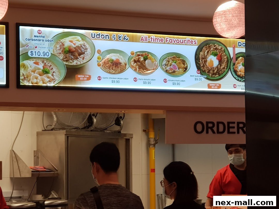 A digital menu board displaying various udon dishes and their prices at Idaten Udon.