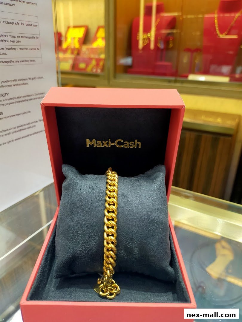 A gold bracelet displayed in a red Maxi-Cash jewelry box.