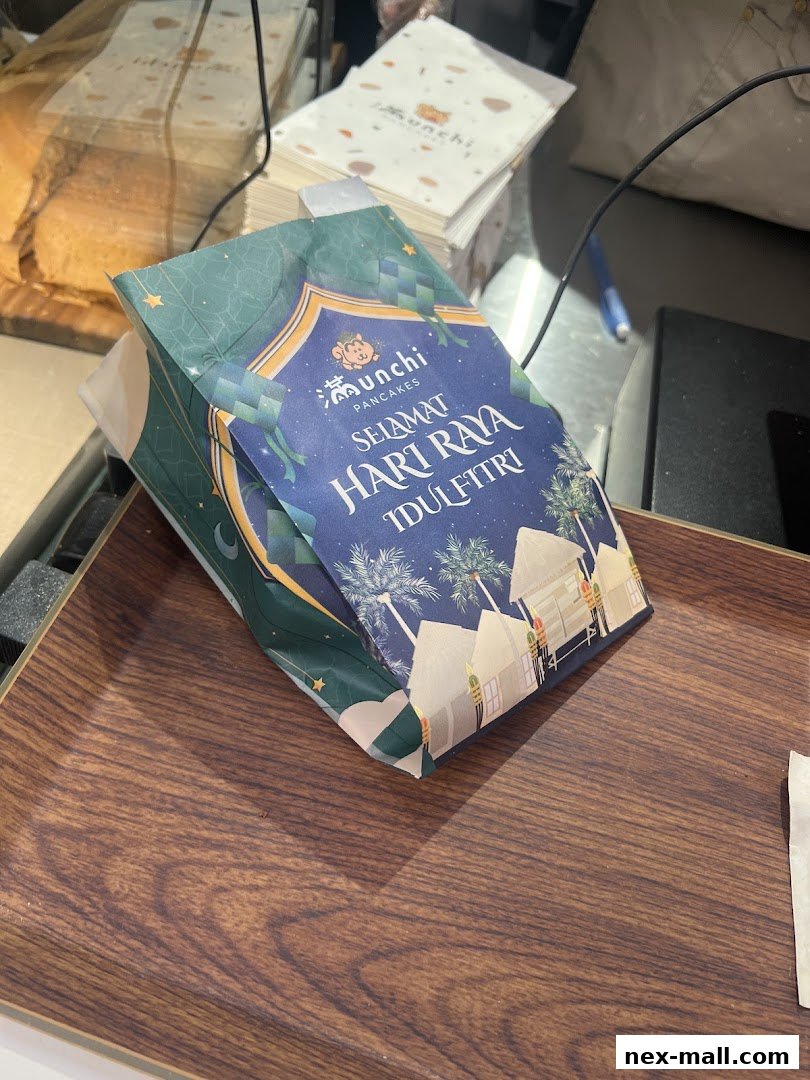A festive paper bag with 'Selamat Hari Raya Aidilfitri' greeting from Munchi Pancakes.