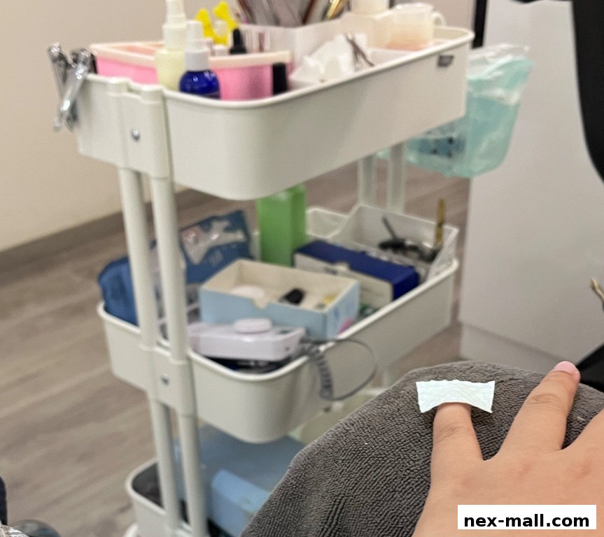 A close-up of a nail technician's cart with various beauty tools and products.