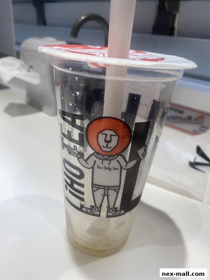 A close-up of a LiHO TEA cup with a straw and condensation.