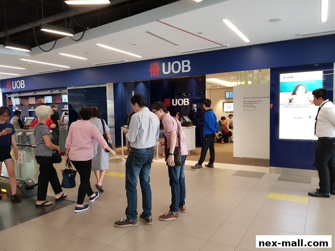People queuing at the entrance of a UOB bank branch with clear signage and digital displays.