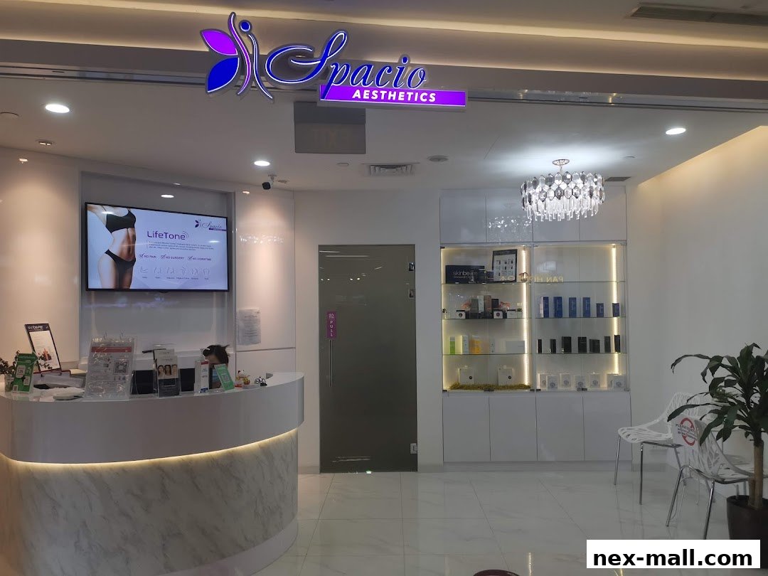 The interior of Spacio Aesthetics, featuring a reception desk, display shelves with products, and a screen showing a body contouring treatment.