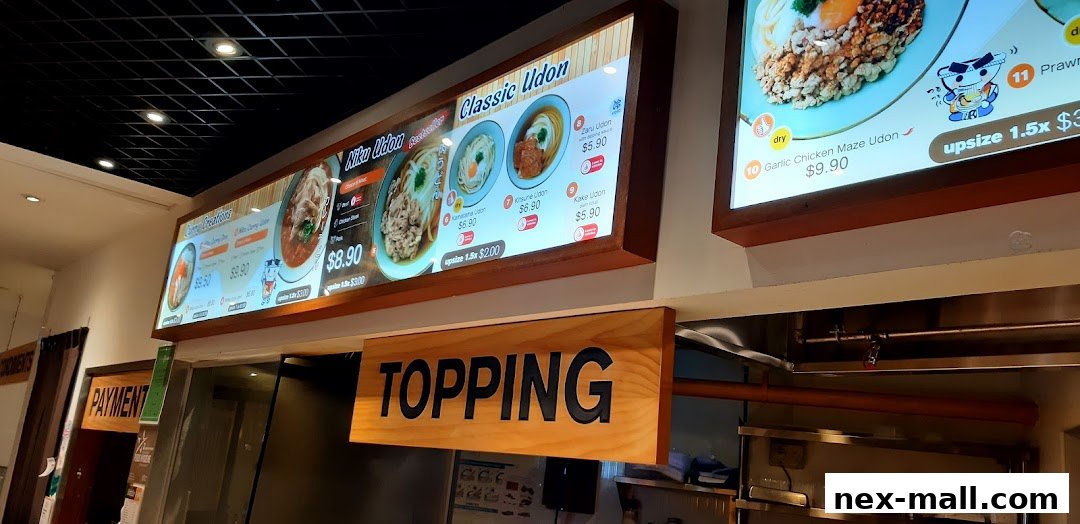 Digital menu boards displaying various udon dishes and prices at Idaten Udon.