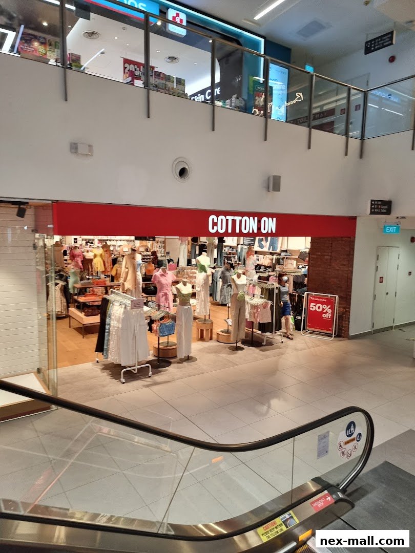 The Cotton On store entrance with clothing displays and a 50% off sign.