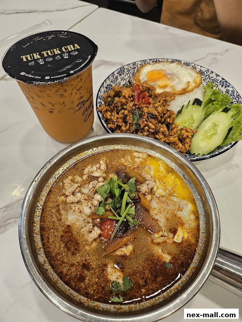 A refreshing Thai iced tea and two delicious Thai dishes, one a rice dish and the other a soup.