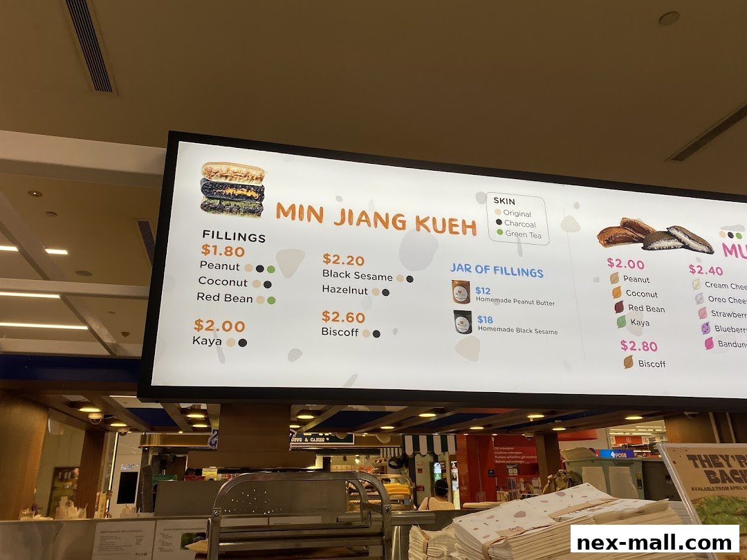 A brightly lit menu board displaying various fillings and options for Min Jiang Kueh.
