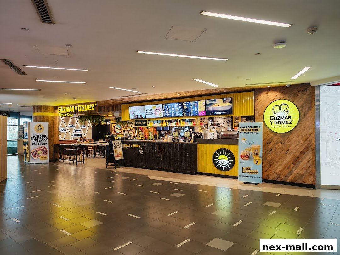The interior of a Guzman y Gomez Mexican restaurant with a counter, seating area, and menu boards.