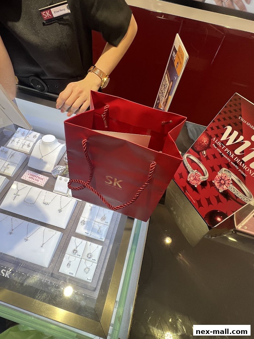 A display of diamond necklaces and rings at SK Jewellery with a red shopping bag.