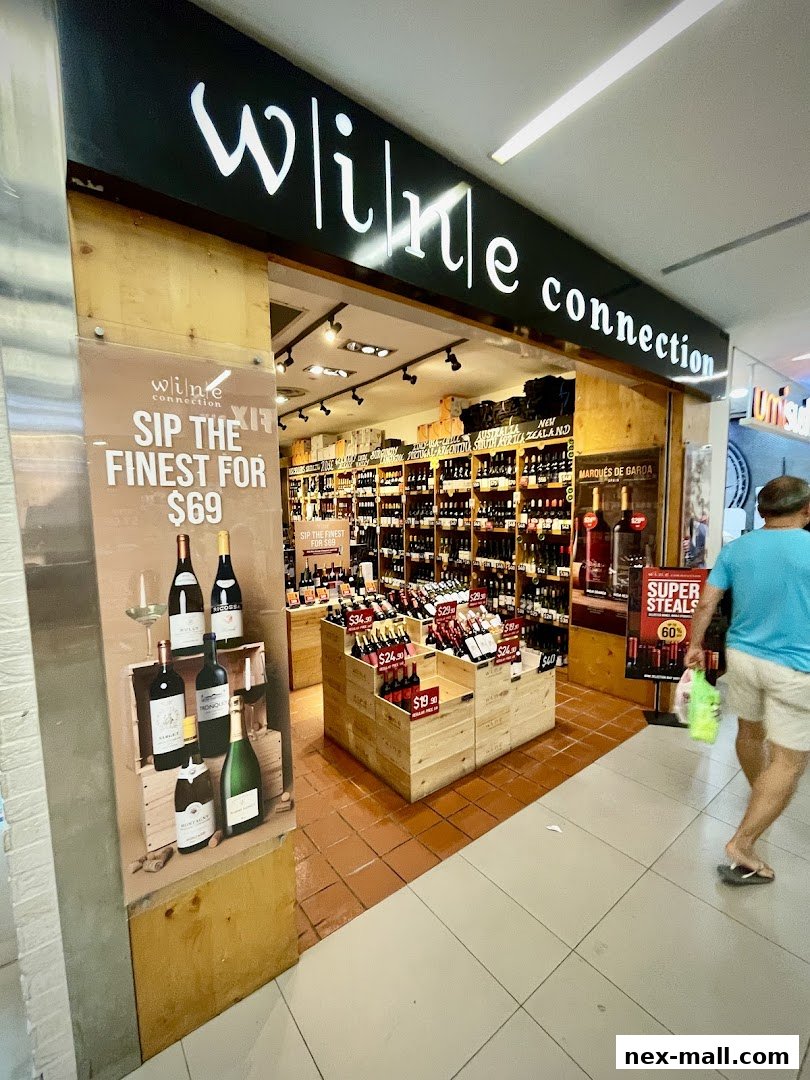 The entrance of a wine shop with bottles displayed and promotional signage.