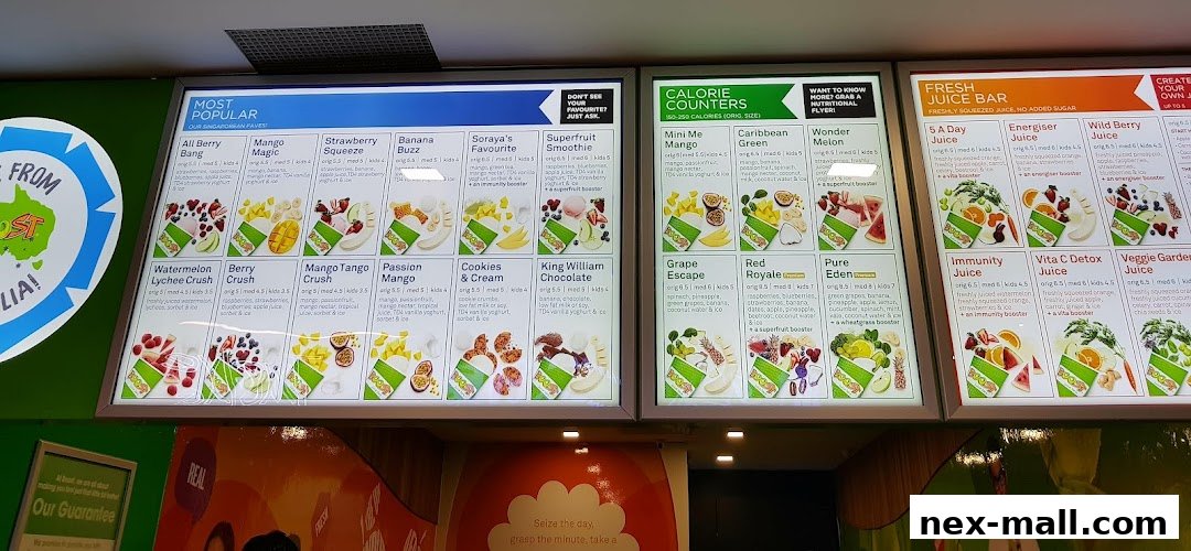 A brightly lit menu board displaying various juices and smoothies with colorful fruit illustrations.