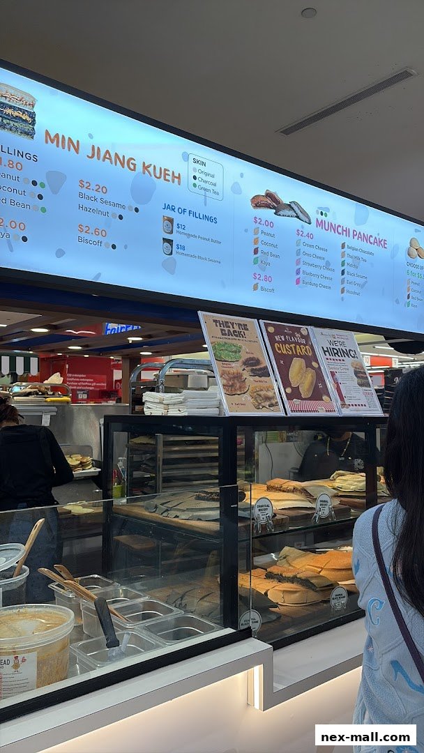 A brightly lit menu board displaying various pancake and filling options at Munchi Pancakes.