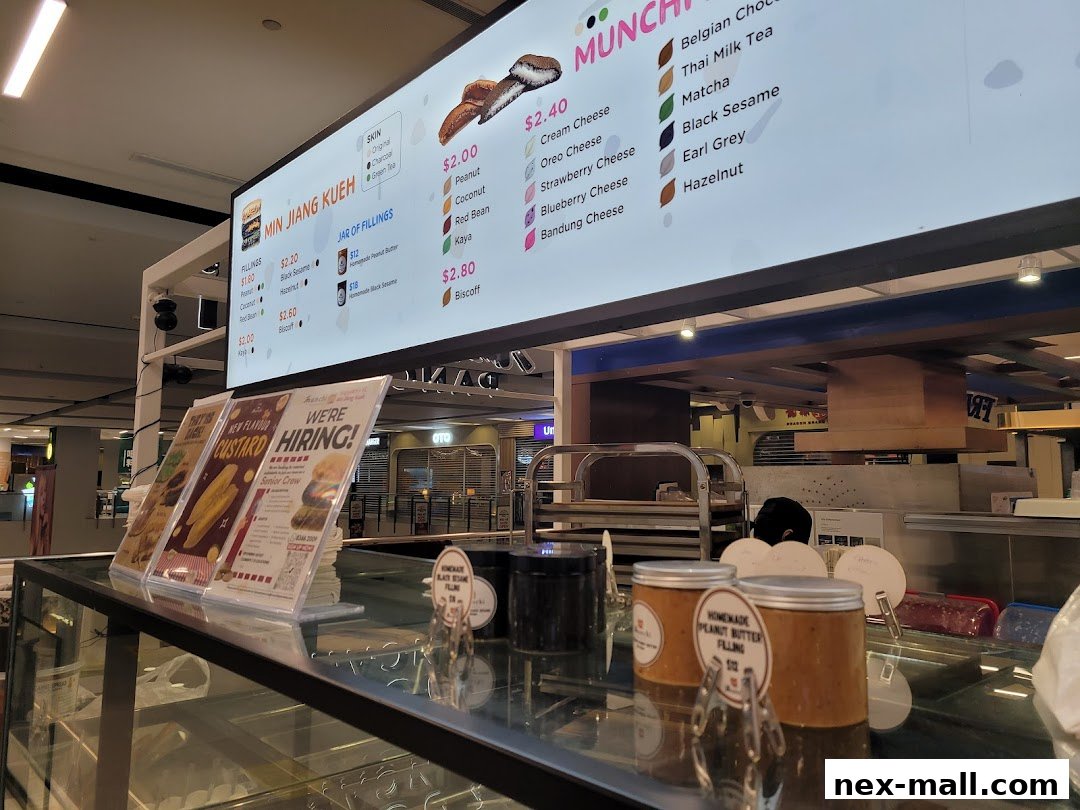 A digital menu board displaying various pancake fillings and drinks at Munchi Pancakes.