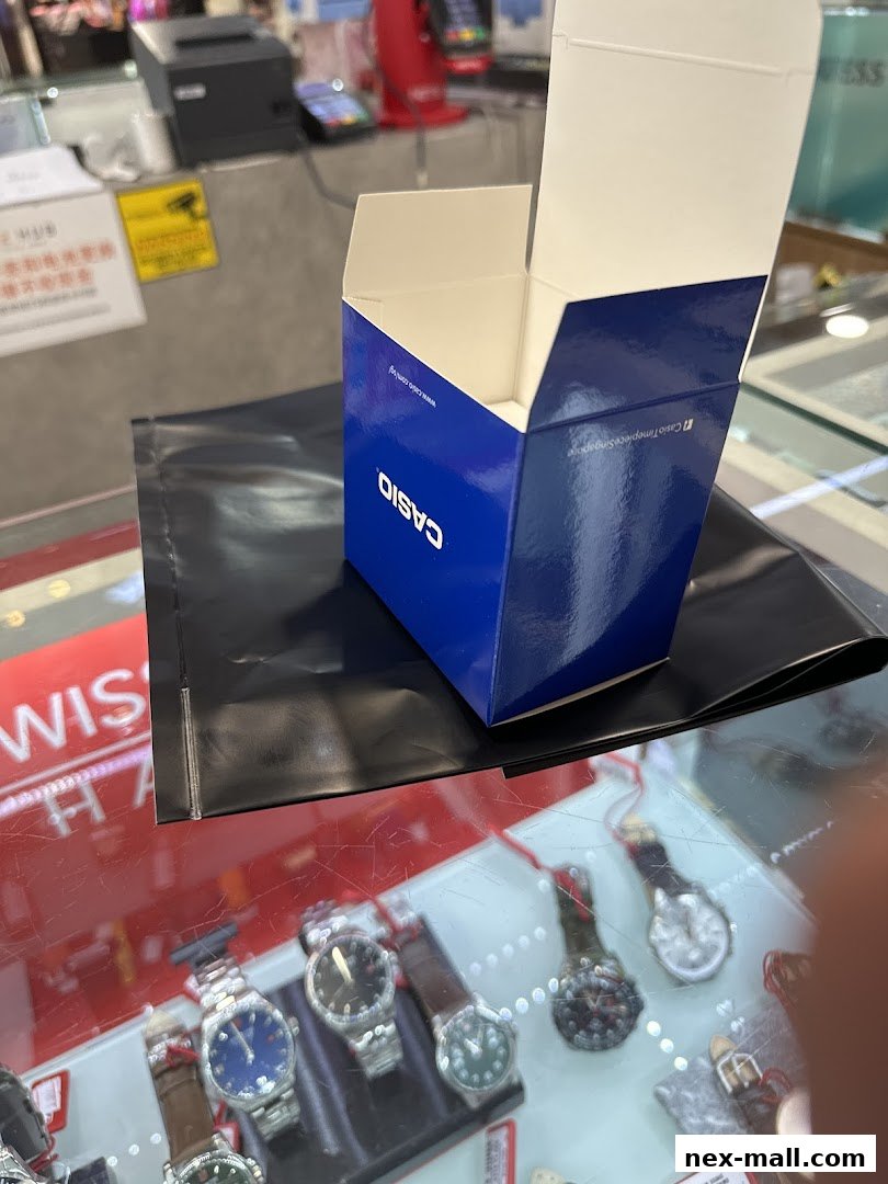 A Casio watch box sits open on a display table with watches in the foreground.