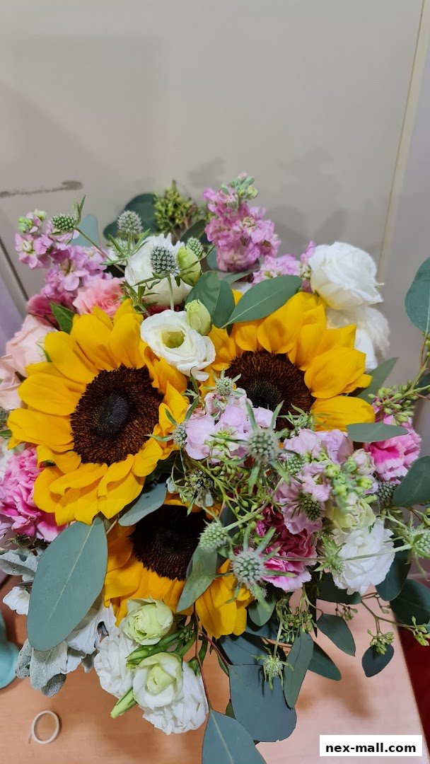 A vibrant bouquet featuring sunflowers, roses, and various other flowers with greenery.