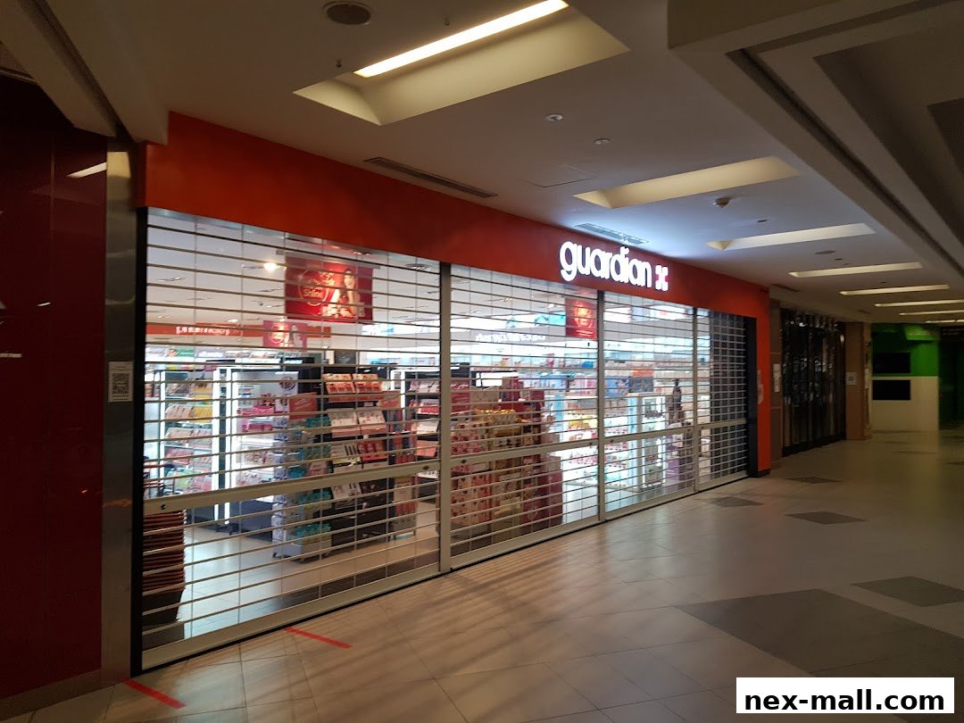 Guardian Health & Beauty Pharmacy store front with roller shutters down.