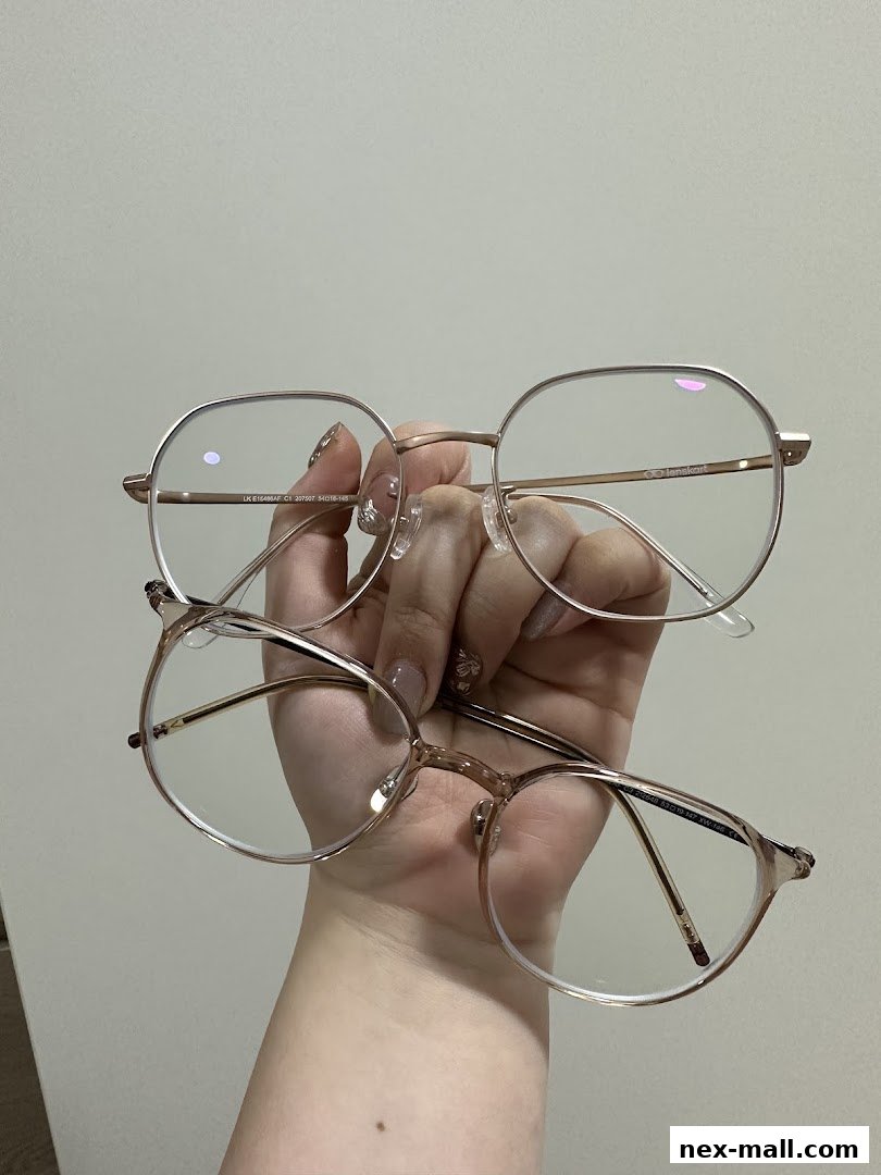 A hand holds two pairs of stylish, rose gold framed eyeglasses.