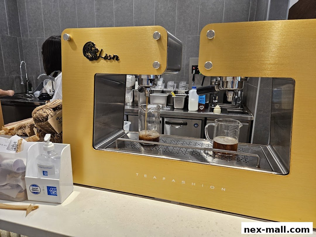 A close-up of a modern, golden tea brewing machine with a logo and text.