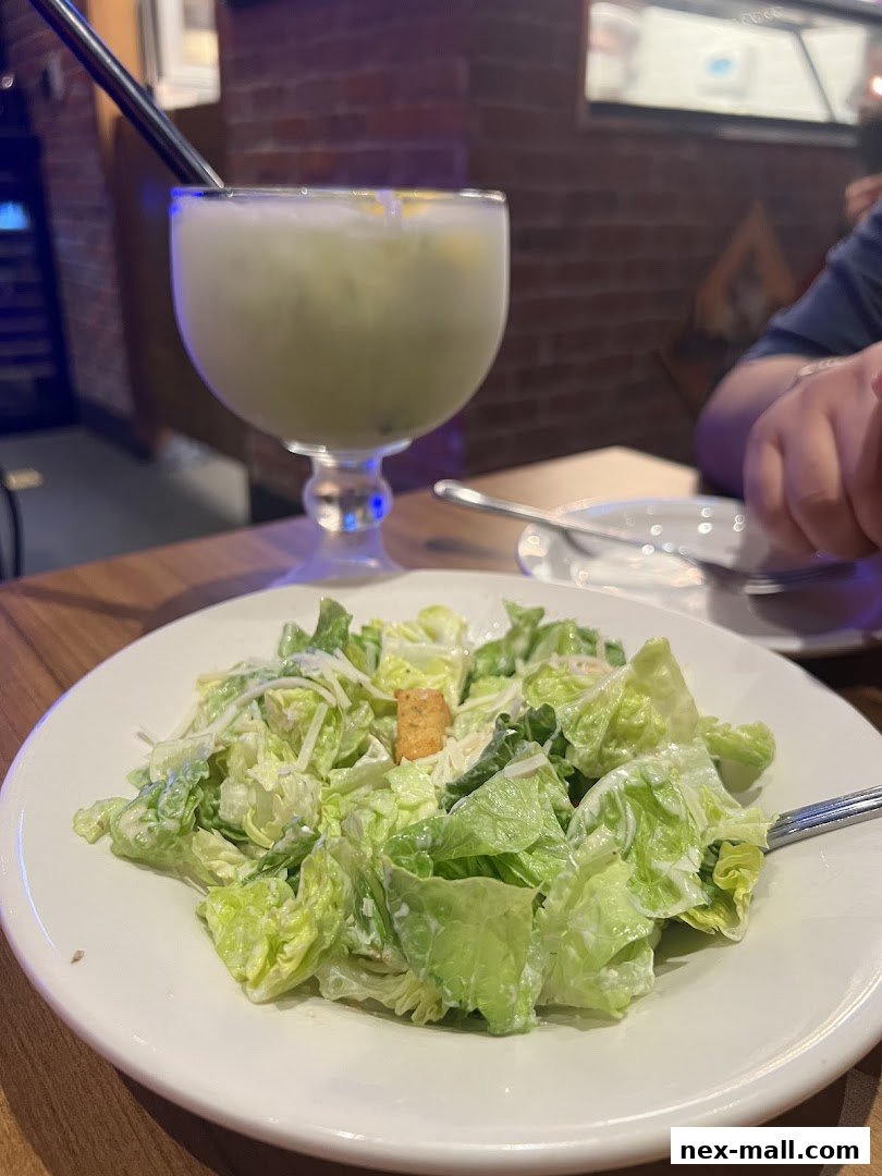 A close-up of a Caesar salad and a refreshing drink at Texas Chicken.