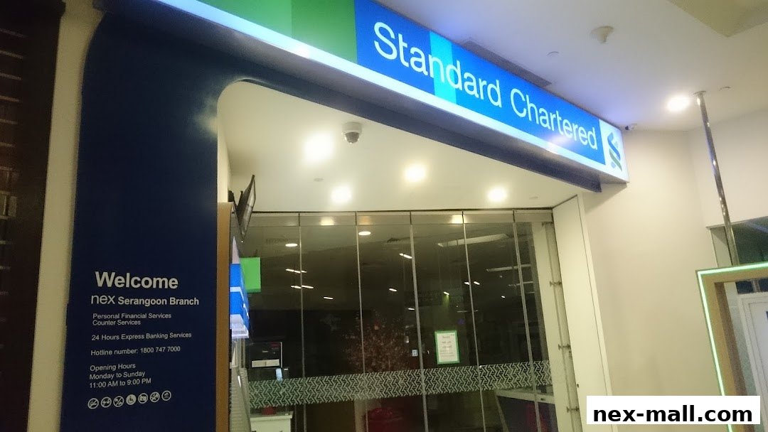 The entrance to a Standard Chartered Bank branch with a prominent sign and welcome information.