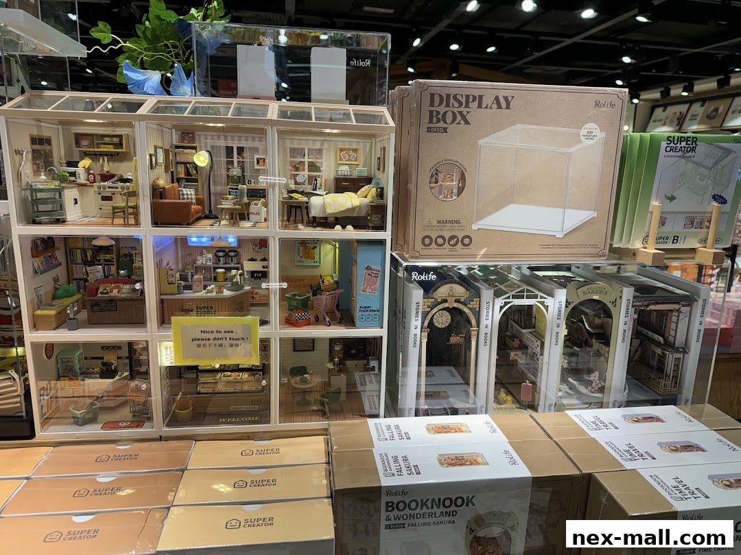 A display of miniature dollhouse kits and display boxes, showcasing detailed scenes.